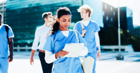 Female nursing student reading paperwork.